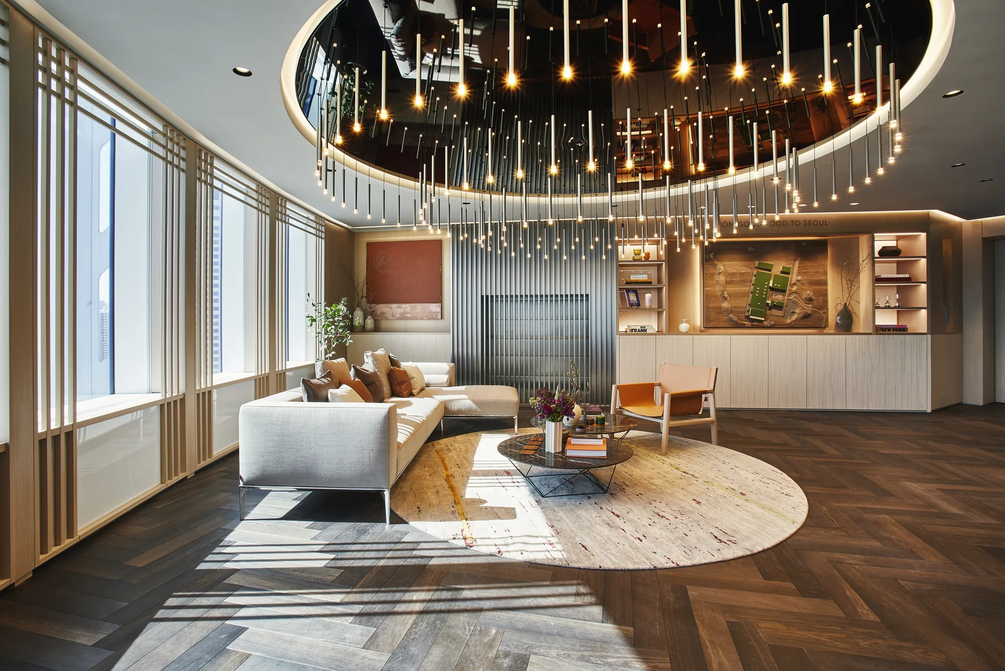 Khu vực chào đón khách tại Private Office Seoul, ghế da và bàn thấp dưới vòng đèn tròn