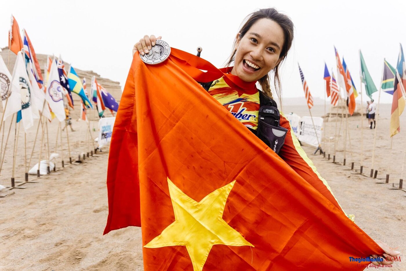 Vũ Phương Thanh giương cờ Việt Nam và huy chương trên sa mạc
