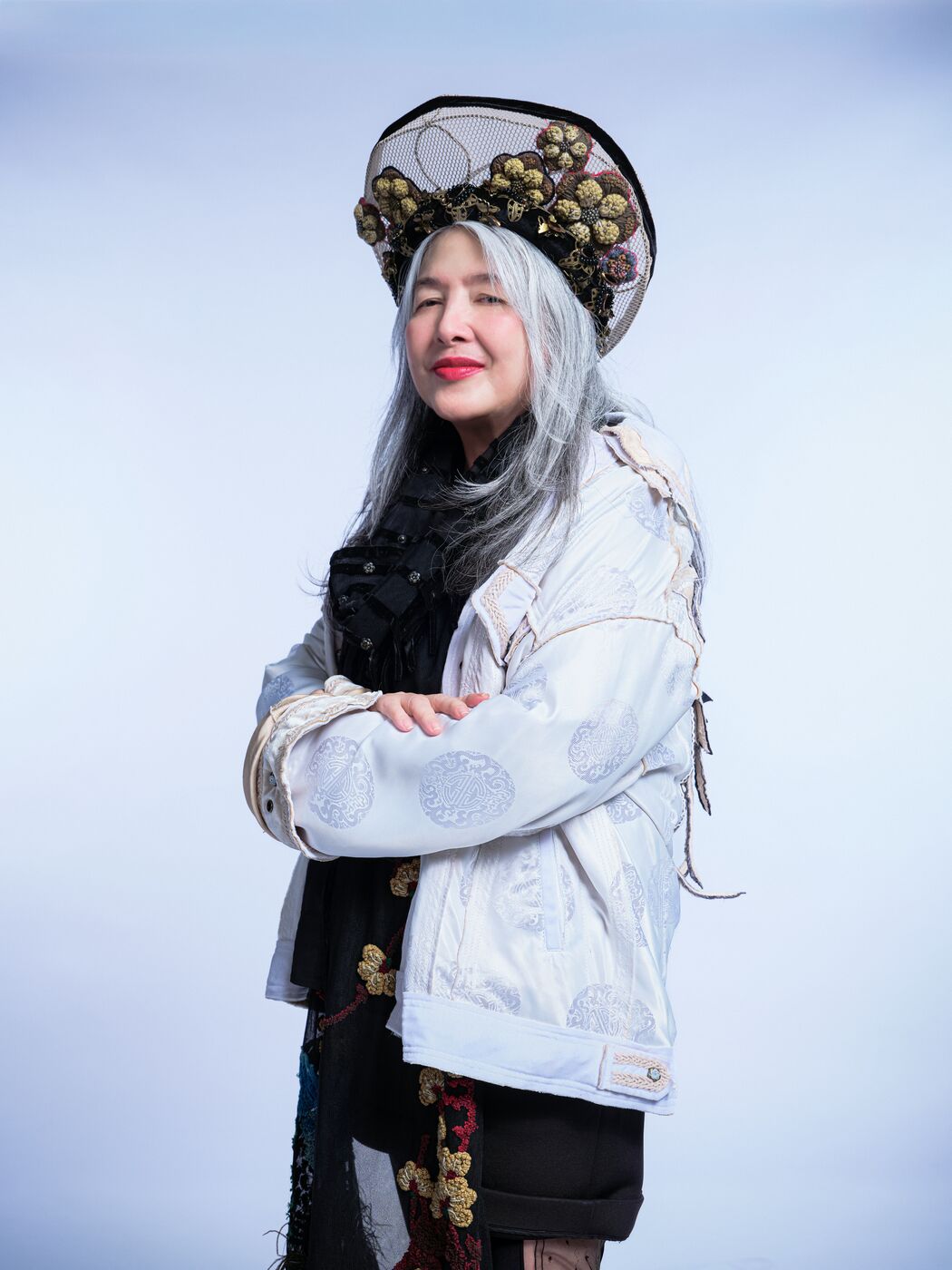 Mai Lâm khoanh tay, đội mũ đính hoa